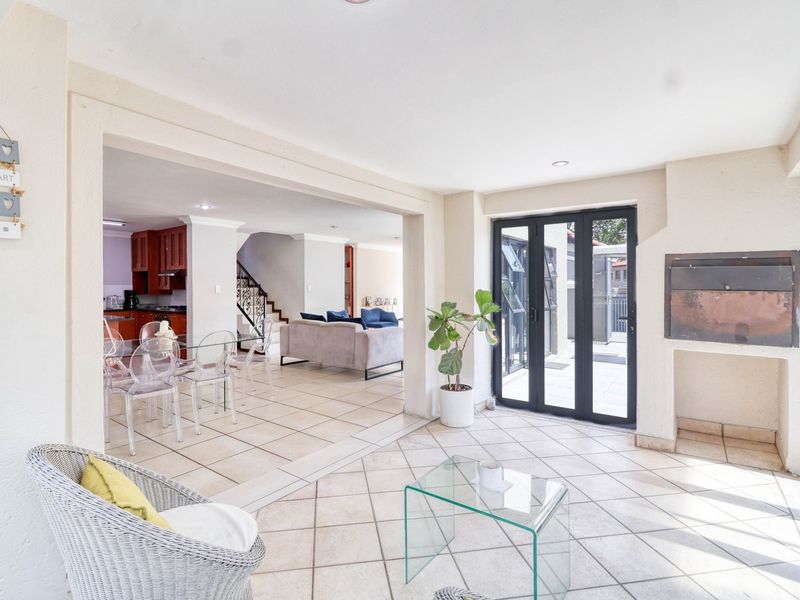 Spacious open-plan living area featuring tiled flooring, a built-in fireplace, and bi-fold doors leading to the outdoor space.