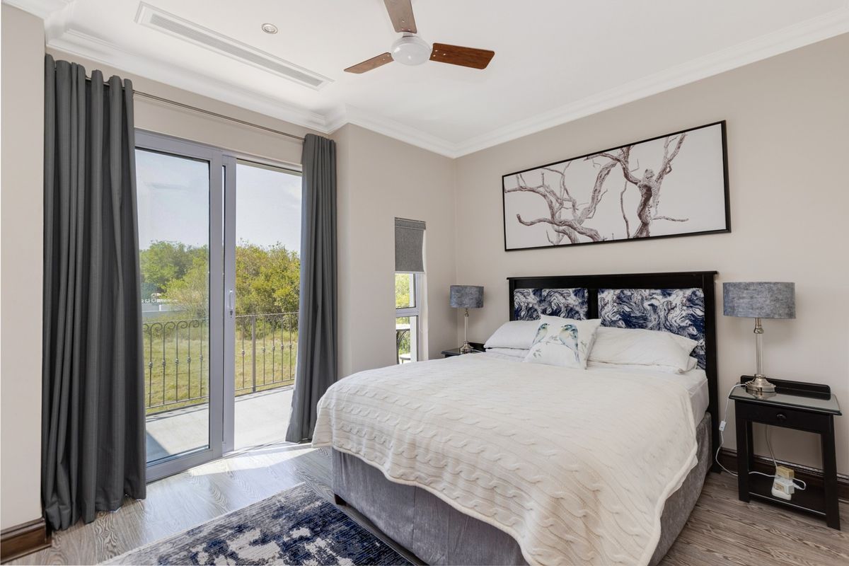 A well-maintained bedroom featuring crown molding, recessed lighting, a ceiling fan, and a sliding glass door leading to an outdoor balcony.