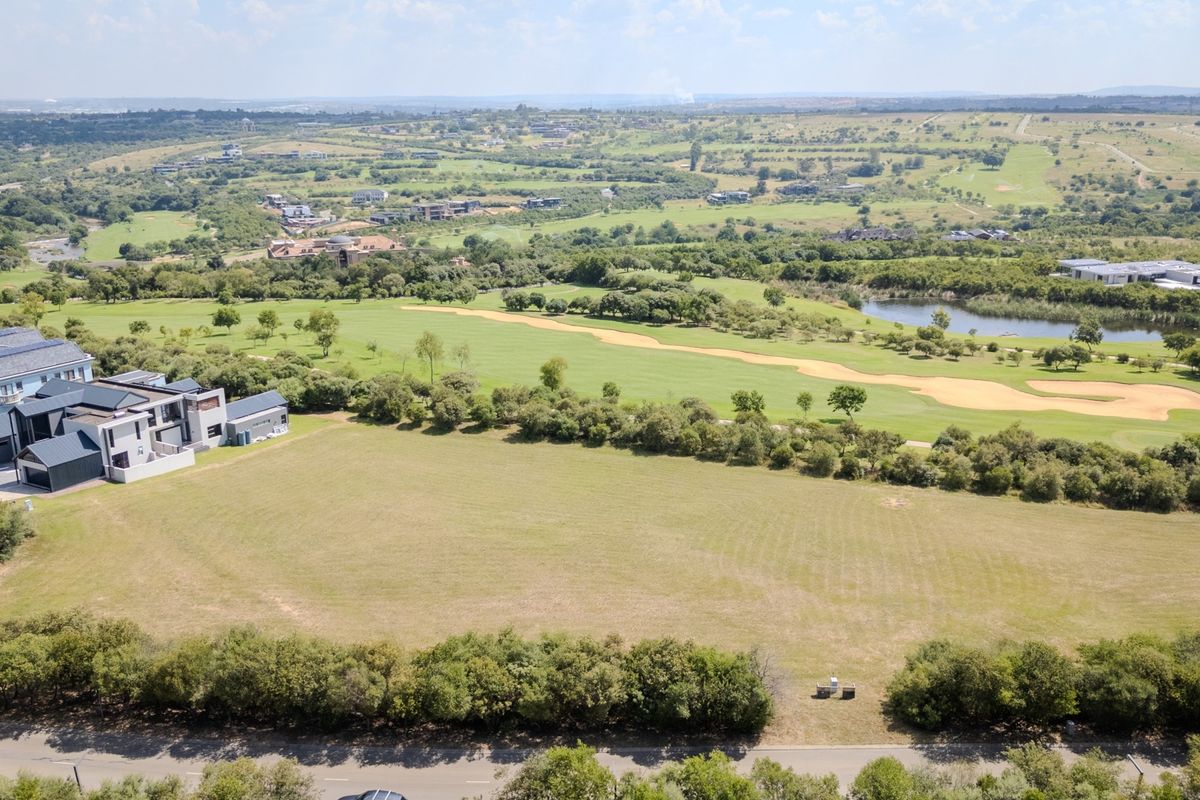 An elevated aerial view of a vacant residential plot situated adjacent to a golf course, offering expansive landscape views.