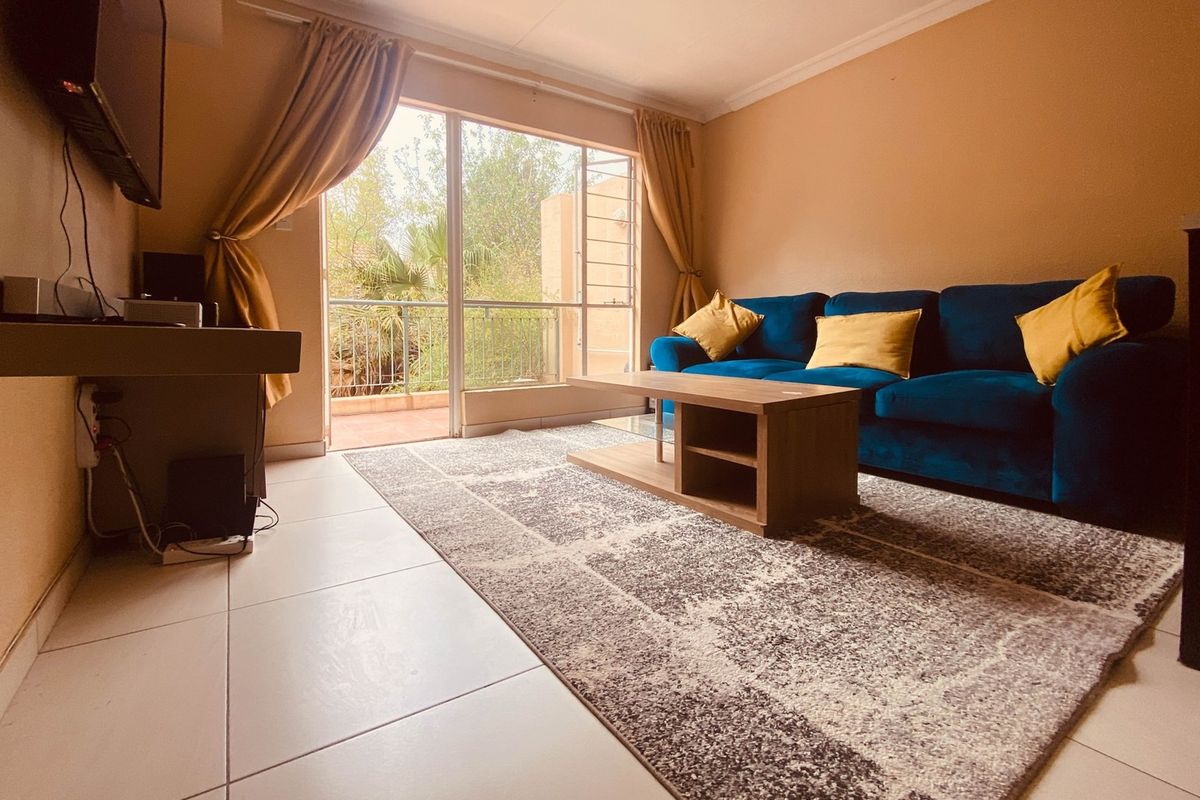 A comfortable living room featuring large sliding glass doors that open onto a private balcony, providing natural light and outdoor access.