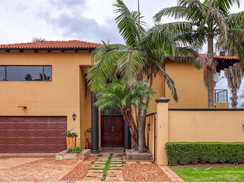 Front elevation of a two-story house featuring a terracotta tiled roof, double garage, and a paved driveway with established landscaping.