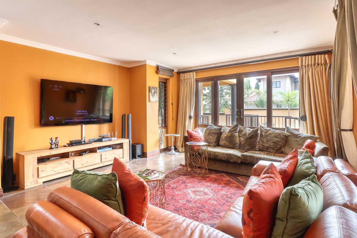 A spacious living room featuring tiled flooring, recessed lighting, and large sliding glass doors that provide access to the outdoor area.