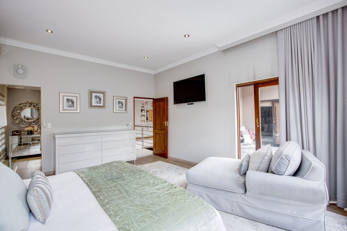 A well-maintained bedroom featuring recessed downlights, coved ceilings, and a sliding glass door providing access to an outdoor area.