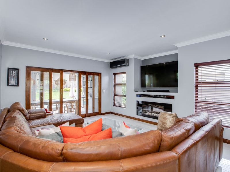 Spacious living room featuring a built-in fireplace, air conditioning, tiled flooring, and large sliding glass doors providing access to the outdoor area.