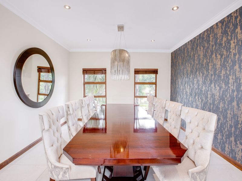Elegant dining room featuring tiled flooring, recessed downlighting, crown molding, and a striking feature wall with textured wallpaper.