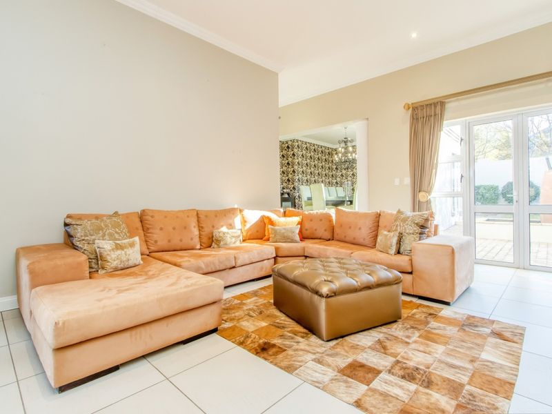 Spacious living room featuring neutral tiled flooring, recessed lighting, and direct access to the outdoor area through a glass sliding door.