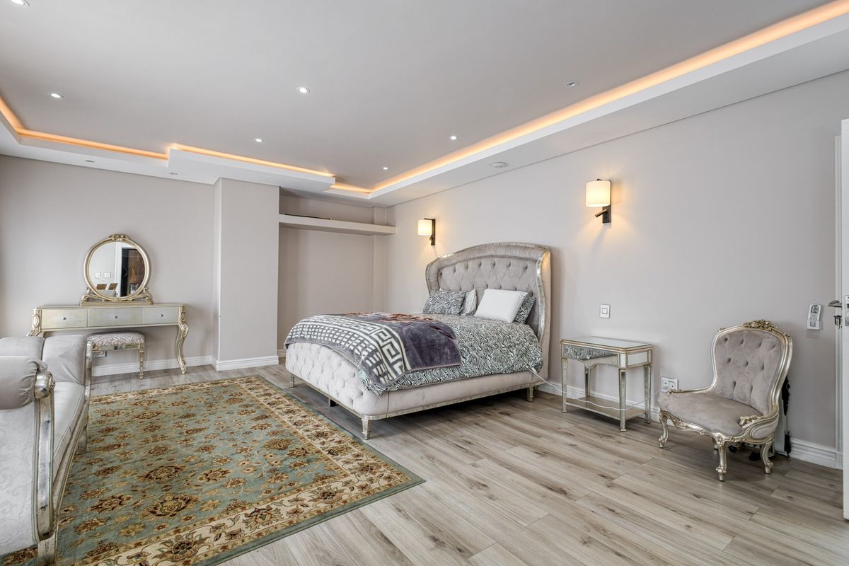Spacious, well-maintained bedroom featuring modern recessed ceiling lighting, cove lighting, and high-quality laminate flooring.