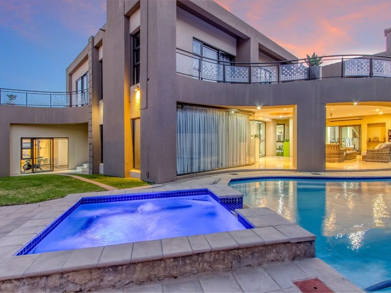Modern multi-level residence featuring a swimming pool, integrated spa, and spacious balcony with glass balustrades, perfect for outdoor entertaining.