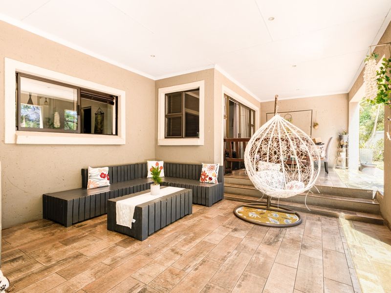 A spacious covered patio featuring wood-look tiled flooring, recessed lighting, and direct access to the interior through sliding glass doors.
