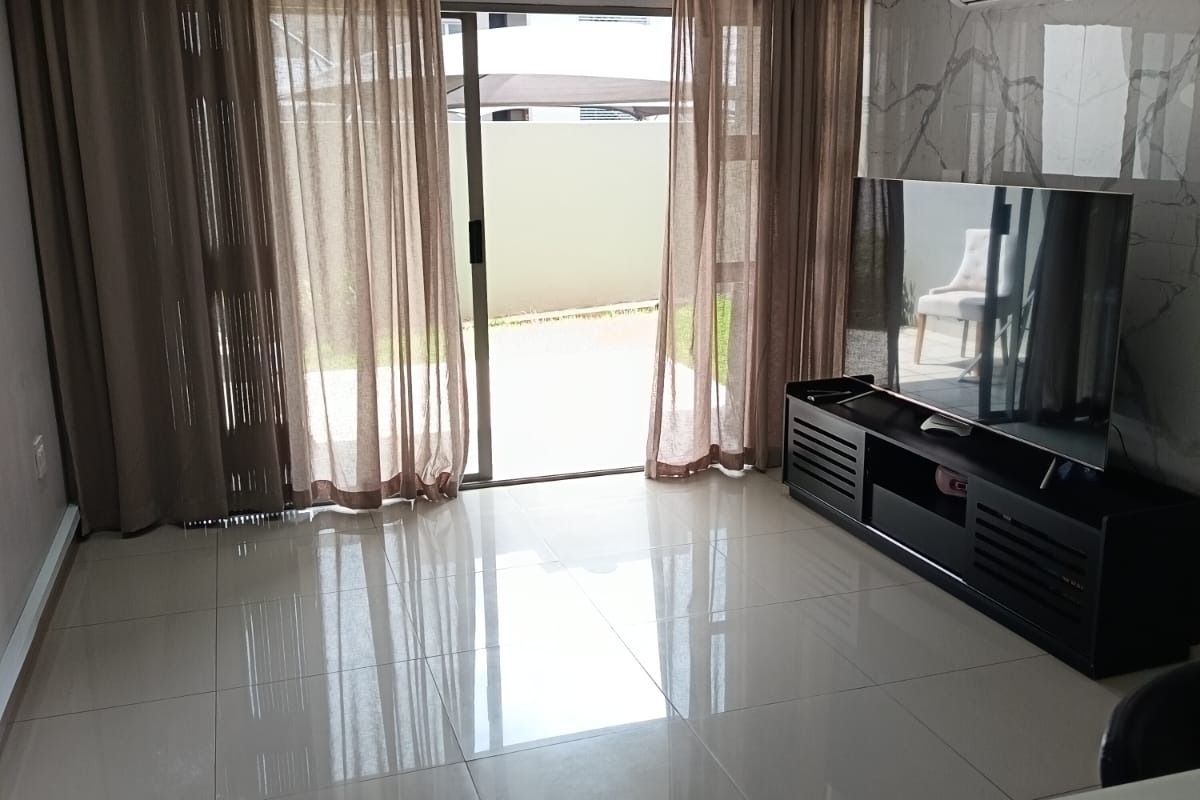 Modern living room featuring polished porcelain floor tiles, marble-effect feature wall, split-system air conditioning, and sliding glass doors leading to an outdoor area.