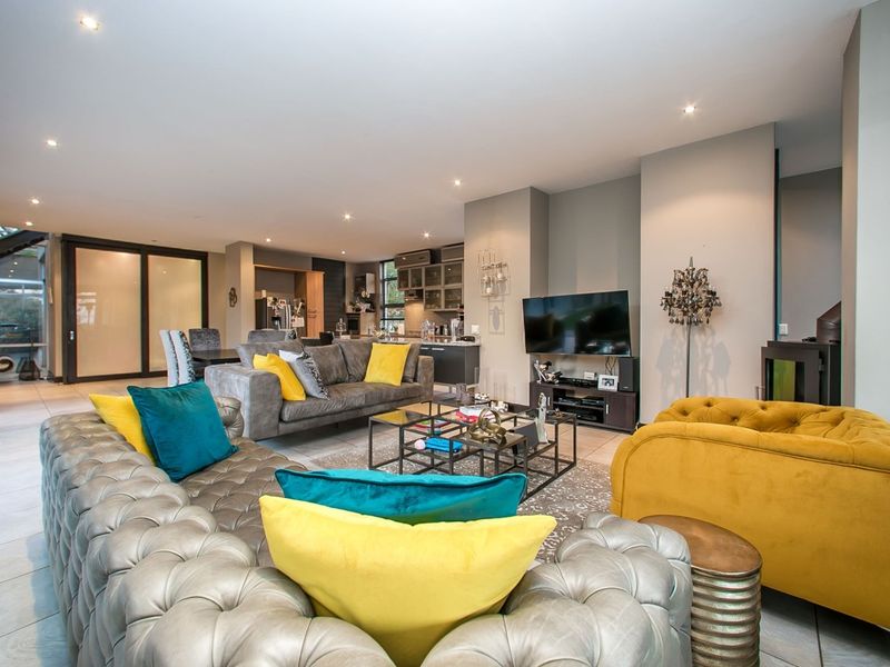 Spacious open-plan living area featuring tiled floors, recessed lighting, and a seamless flow between the lounge and kitchen space.