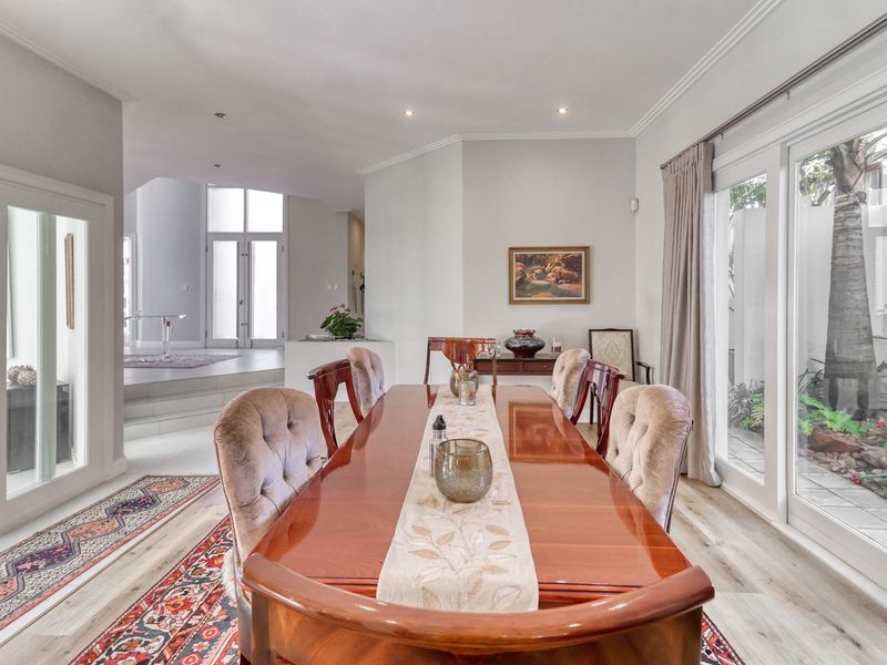 Spacious dining room featuring laminate flooring, recessed lighting, and large sliding glass doors that provide natural light and access to the outdoor area.