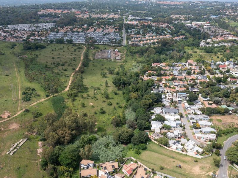 An aerial view of the vacant residential land parcel, showcasing its position relative to the surrounding established suburban neighborhood and local landscape.