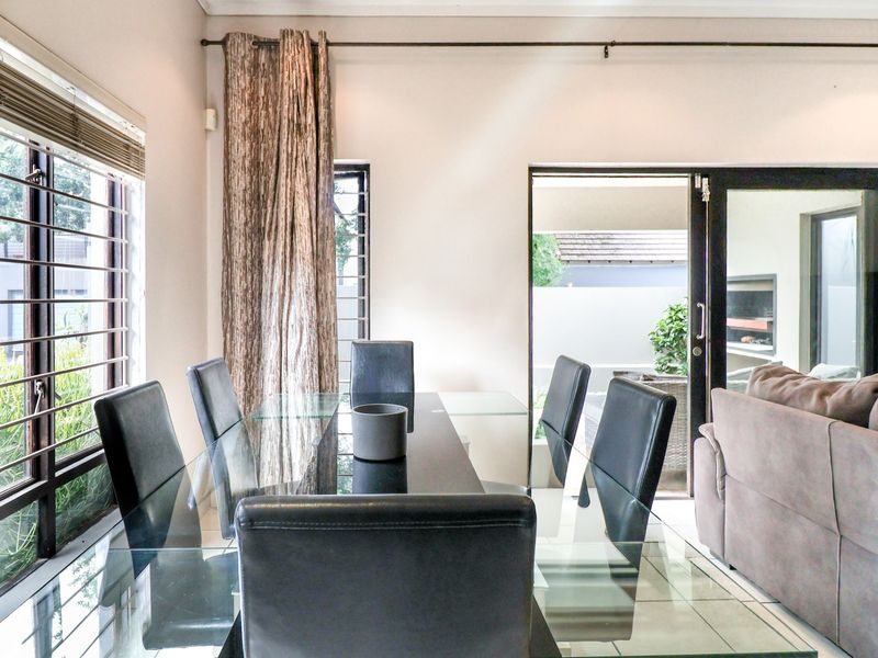 Open plan dining area featuring tiled floors and large sliding glass doors providing seamless access to the outdoor patio space.