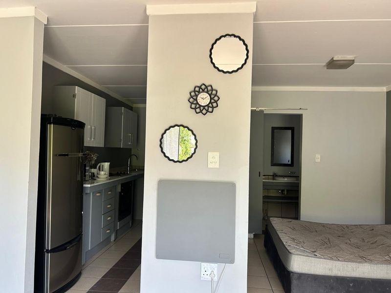 Open-plan apartment layout featuring a functional kitchen area with built-in cabinetry and appliances, adjacent to a living space and bathroom access.