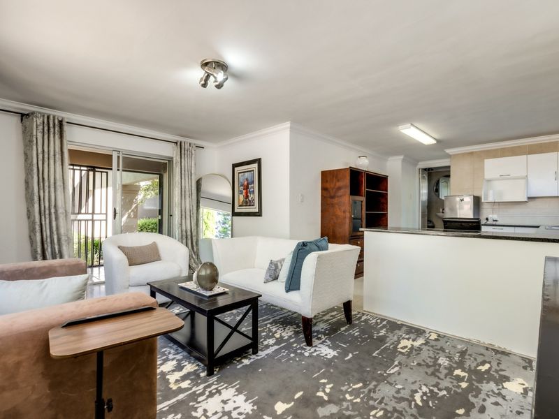 An open-plan living area featuring a kitchen with granite countertops and a sliding glass door leading to an outdoor space.