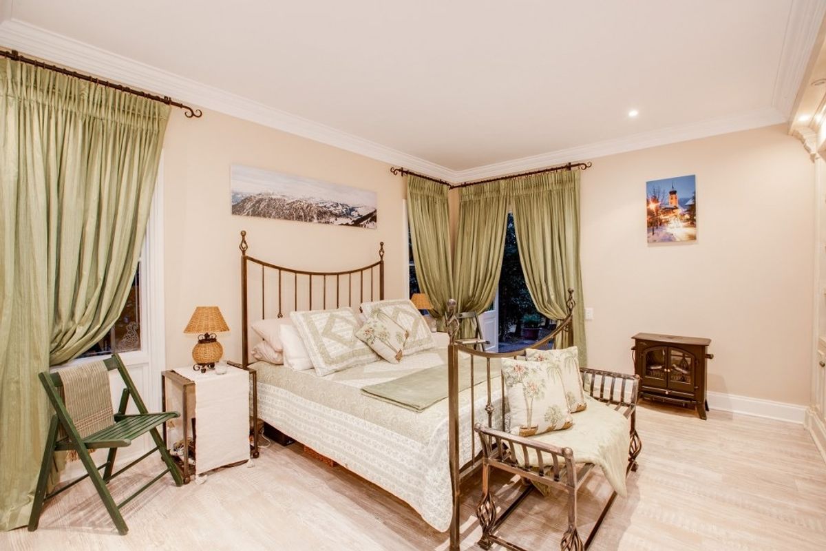 A well-maintained bedroom featuring crown molding, recessed lighting, and direct access to the outdoors through glass-paned french doors.