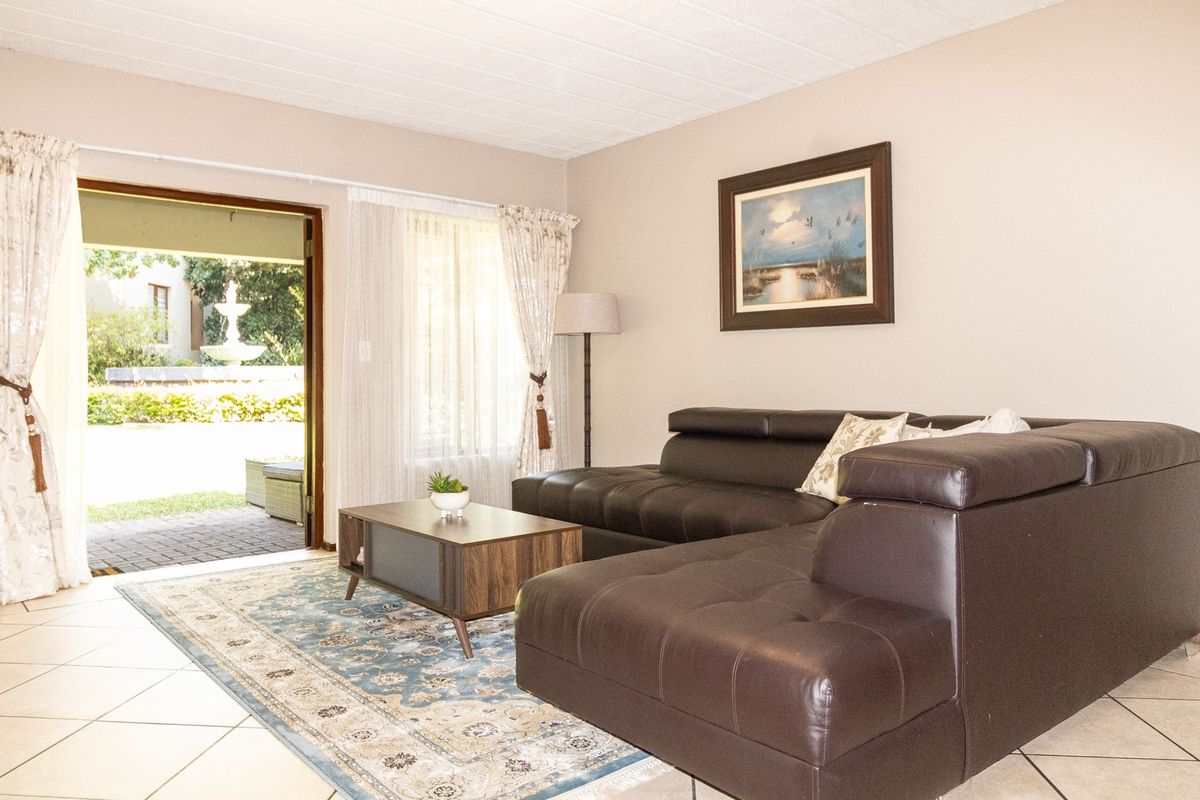 A comfortable living room featuring tiled flooring and a sliding glass door that provides direct access to an outdoor patio area.