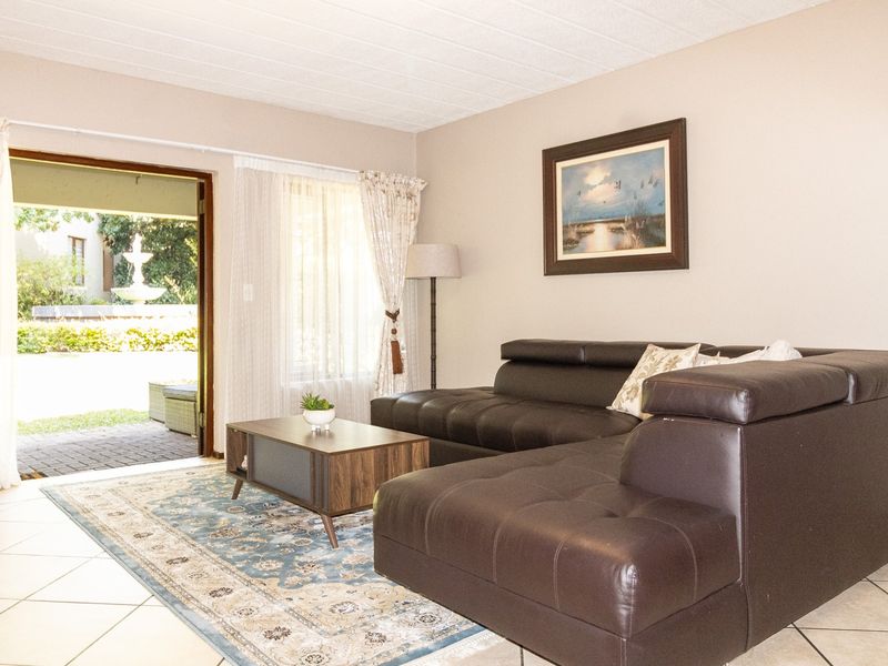 A comfortable living room featuring tiled flooring and a sliding glass door that provides direct access to an outdoor patio area.