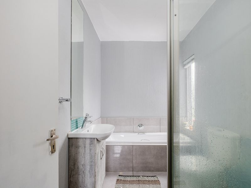 A functional bathroom featuring a vanity with basin, a bathtub, and a separate shower enclosure with glass door.