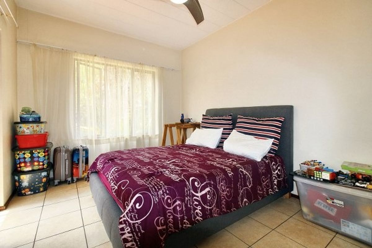 A functional bedroom featuring tiled flooring and a ceiling fan, offering a neutral base for personalization.