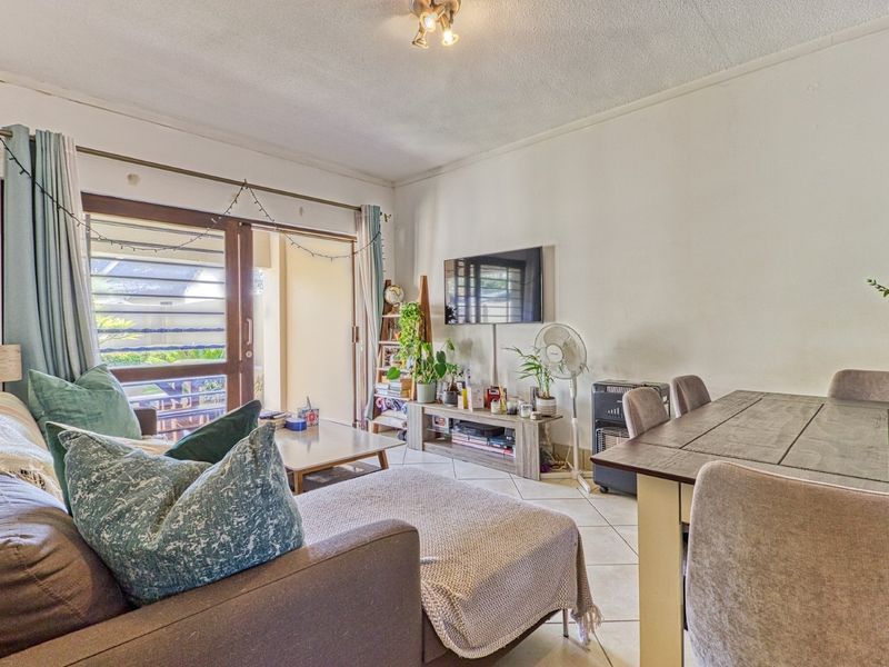 Open plan living and dining area featuring tiled flooring and a sliding glass door providing access to the outdoor space.