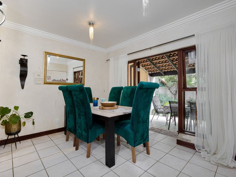 Dining room featuring tiled flooring, crown molding, and a sliding glass door providing access to the outdoor patio area.