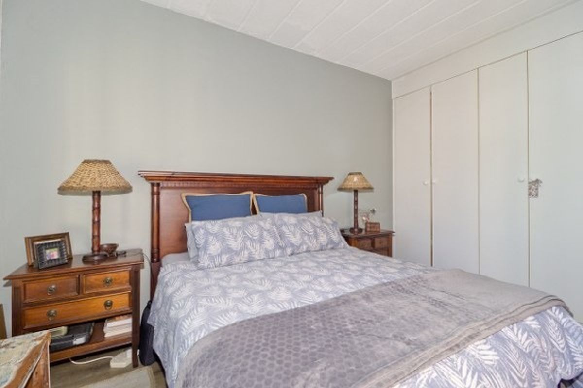 A comfortable bedroom featuring built-in cupboards and neutral wall finishes, providing a functional and well-maintained sleeping space.