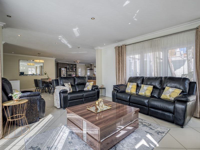 Spacious open-plan living and dining area featuring tiled floors, recessed lighting, and large sliding doors providing ample natural light.