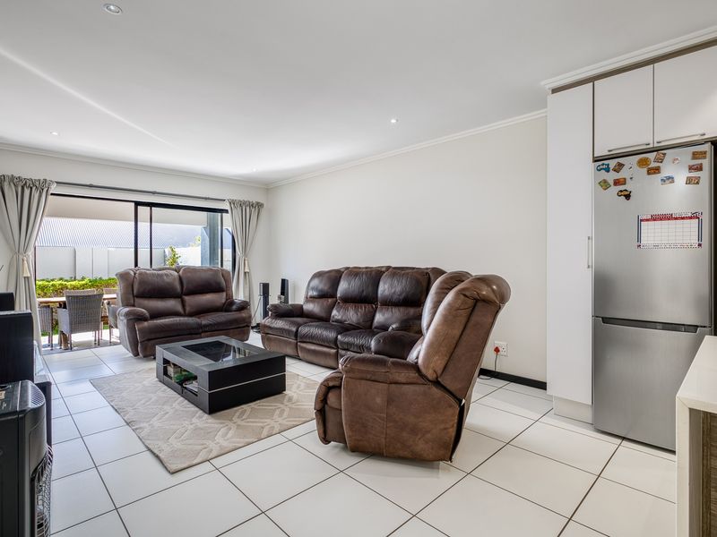 Open-plan living area featuring tiled floors, recessed lighting, and direct access to an outdoor patio through sliding glass doors.