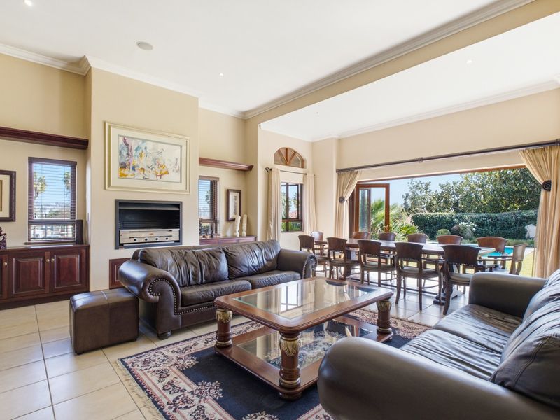Spacious open-plan living and dining area featuring a built-in fireplace, tiled floors, and large stacking doors opening to the garden.