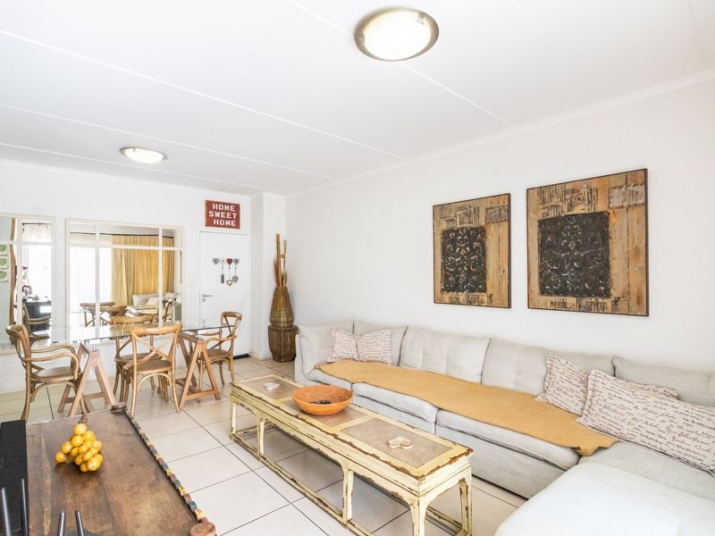 An open-plan living and dining area featuring neutral tiled flooring and simple ceiling lighting, offering a functional and versatile space.