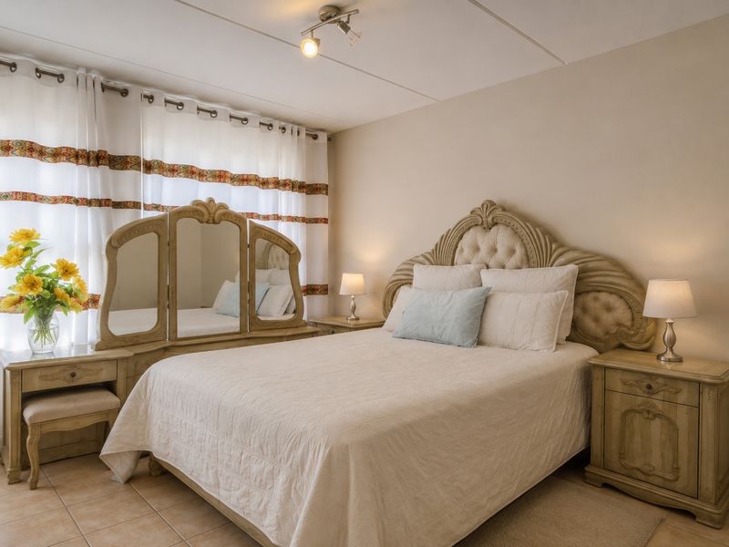 A well-maintained bedroom featuring neutral wall tones, tiled flooring, and a functional ceiling light fixture.