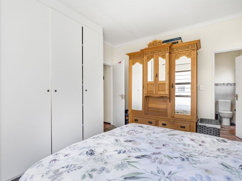 A bedroom featuring built-in white cupboards and direct access to an en-suite bathroom.