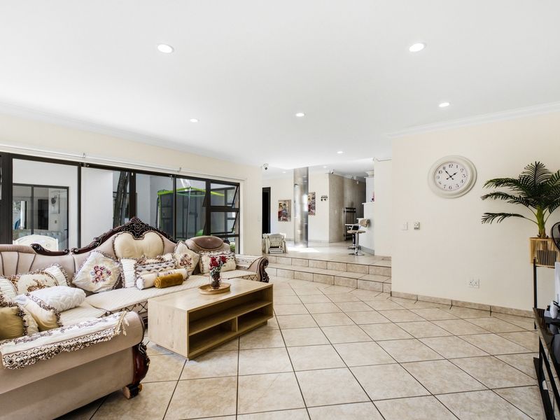 Spacious open-plan living area featuring tiled floors, recessed lighting, and large sliding glass doors that provide seamless access to the outdoor space.