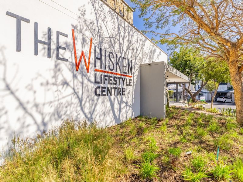 Exterior view of The Whisken Lifestyle Centre featuring modern building signage and well-maintained landscaped garden areas.