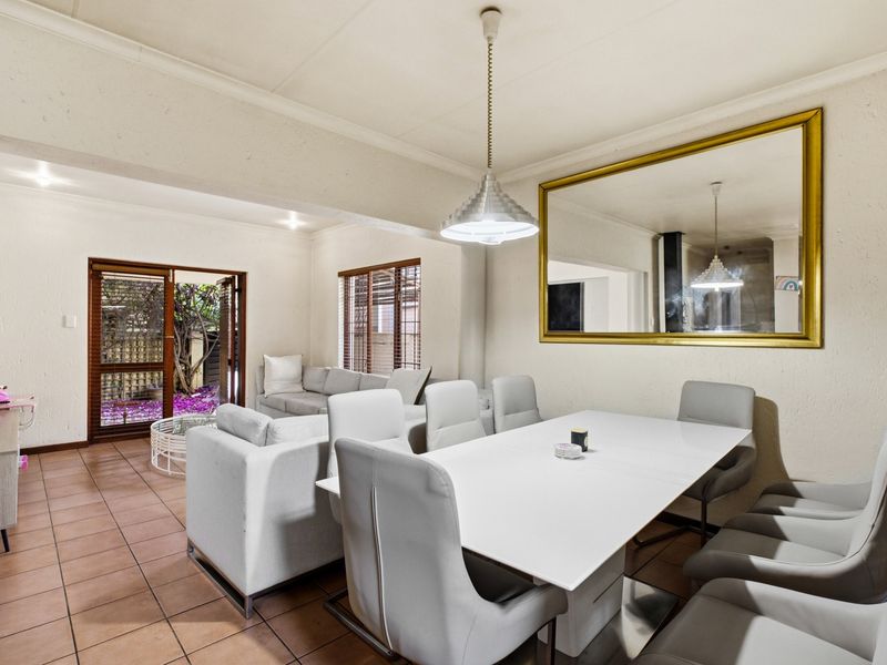 Spacious open-plan living and dining area featuring tiled flooring, large sliding doors to the garden, and neutral finishes ready for modern updates.