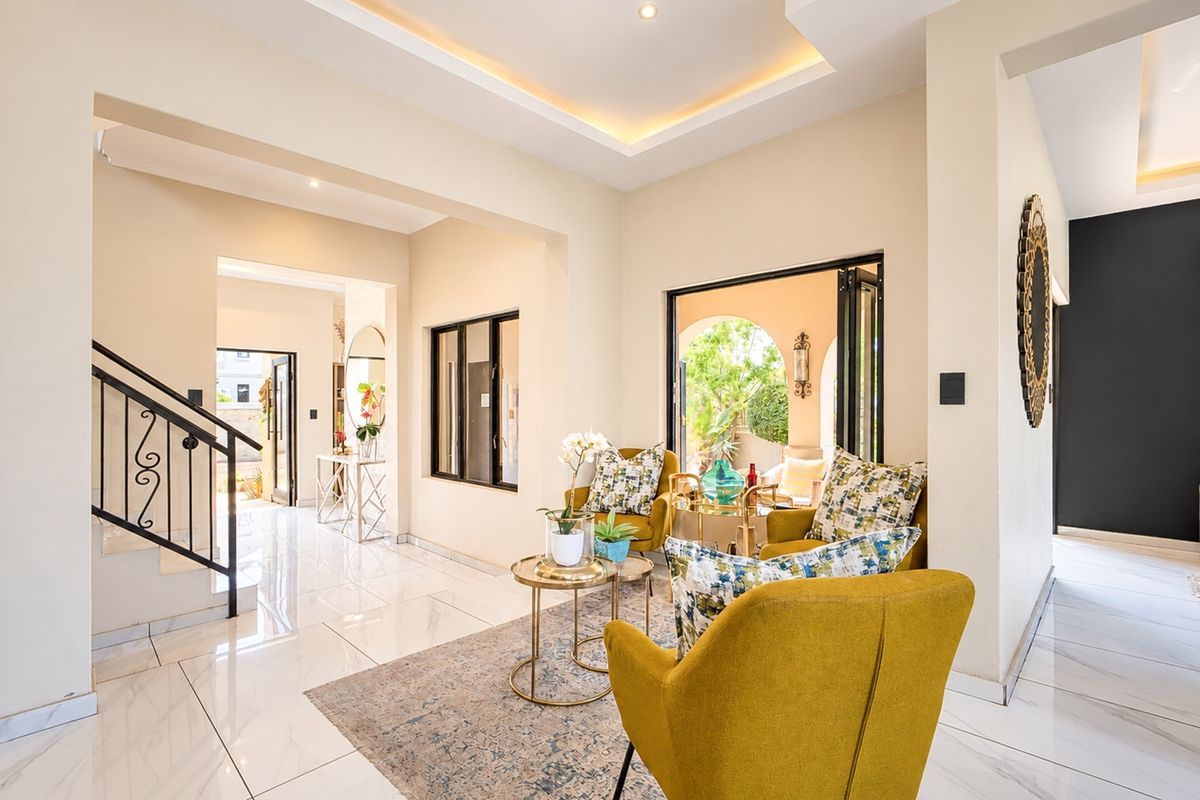 Bright and modern living area featuring elegant porcelain flooring, recessed ceiling lighting, and seamless access to the outdoor patio through bi-fold doors.