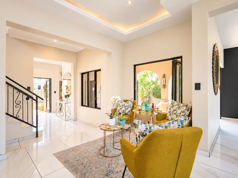 Bright and modern living area featuring elegant porcelain flooring, recessed ceiling lighting, and seamless access to the outdoor patio through bi-fold doors.