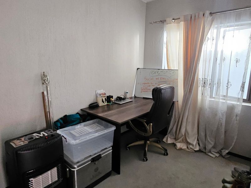 A functional home office space featuring a window with curtains, providing natural light and a dedicated area for work or study.