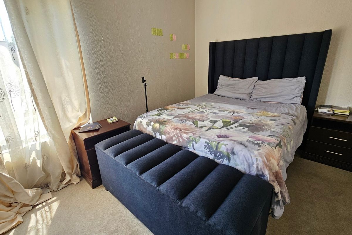 A standard bedroom featuring carpeted flooring and textured wall finishes, providing a functional space for rest.