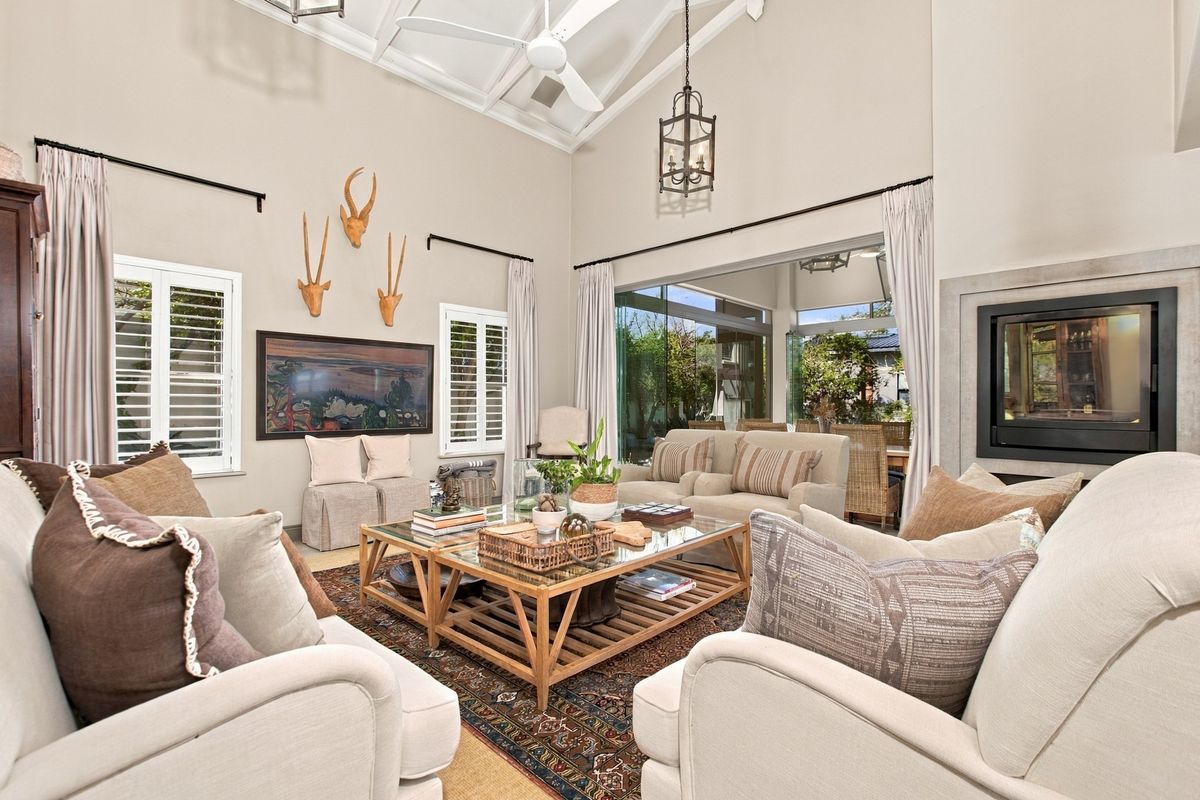 Spacious living room featuring a high vaulted ceiling with exposed rafters, a built-in fireplace, and large sliding glass doors leading to an outdoor area.