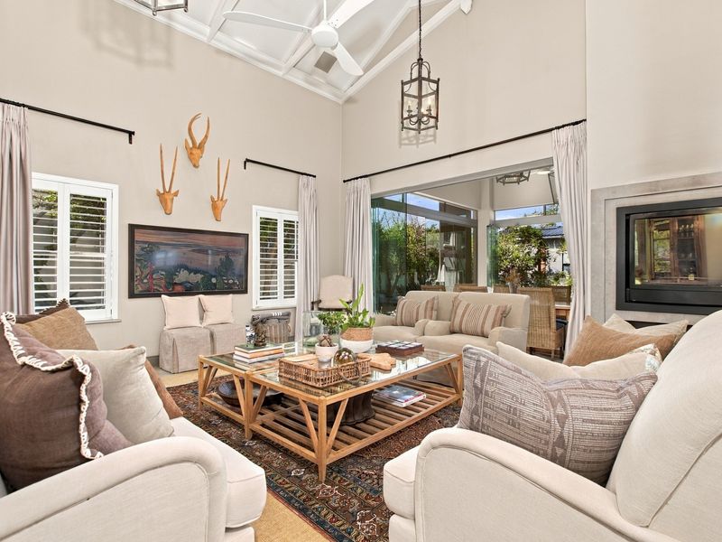 Spacious living room featuring a high vaulted ceiling with exposed rafters, a built-in fireplace, and large sliding glass doors leading to an outdoor area.