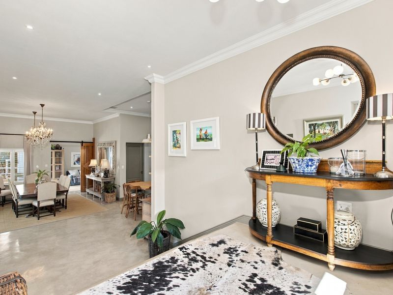 Spacious open-plan living and dining area featuring polished concrete floors, elegant crown molding, and recessed lighting, creating a bright and cohesive interior space.