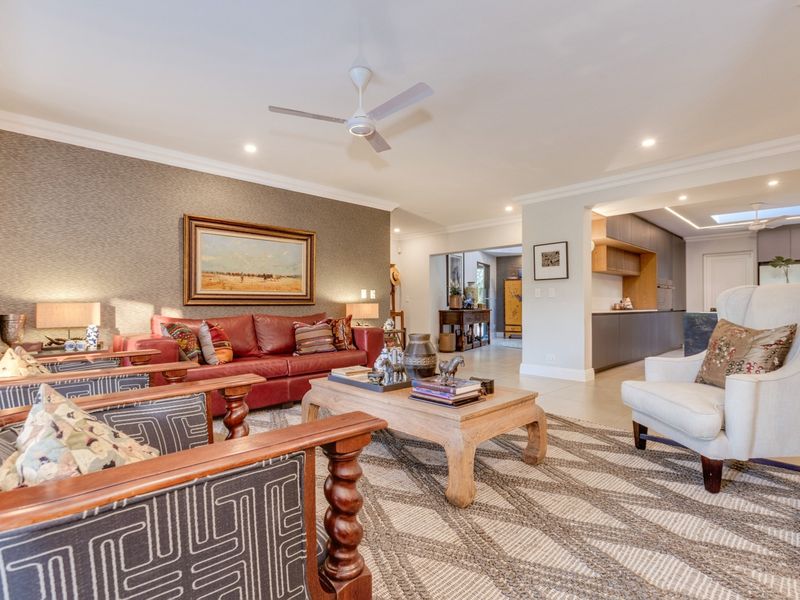 Spacious open-plan living area featuring a modern kitchen with integrated cabinetry, recessed lighting, and a skylight, seamlessly flowing into the comfortable lounge space.