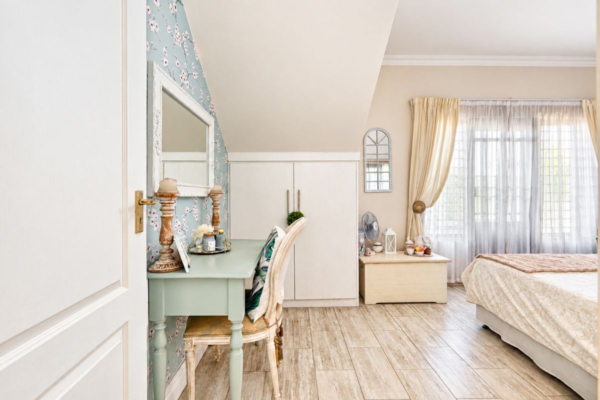 A well-maintained bedroom featuring tiled flooring, a sloped ceiling, and a built-in wardrobe, offering a cozy and functional living space.