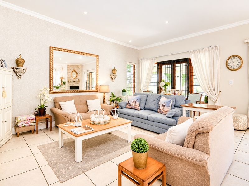 A bright and well-maintained living room featuring tiled flooring, recessed lighting, and sliding glass doors with security gates leading to the exterior.