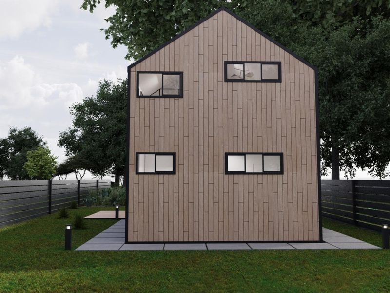 Rear view of a modern townhouse featuring timber cladding, black-framed windows, and a landscaped garden with paved patio area.