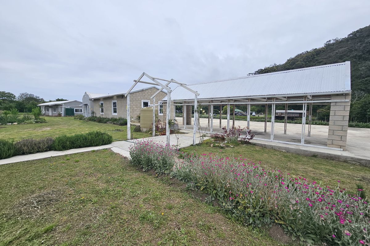Spacious outdoor area featuring a covered walkway, concrete slab, and landscaped garden, providing versatile space for restaurant patrons or events.