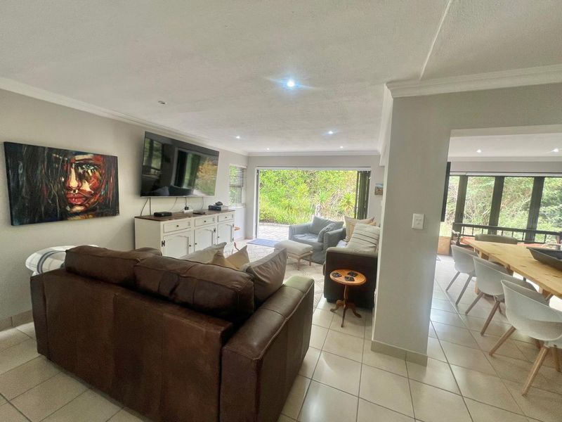 Open plan living and dining area featuring tiled flooring, recessed lighting, and large stacking glass doors providing seamless access to the outdoor space.